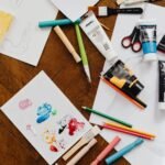 A vibrant flatlay of various art supplies on a wooden table, ideal for creative projects.
