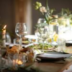 a table set for a formal dinner with wine glasses and plates